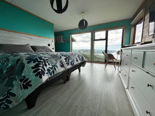 1 dormitorio con cama y pared verde en Bella casa de campo con panorámica vista al mar, en Dalcahue