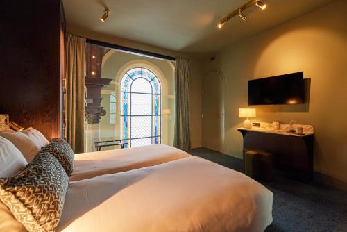 a bedroom with a large bed and a window at Heavens Hotel in Hoorn