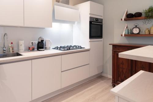 a white kitchen with a sink and a stove at Kustappartementenkatwijk 2F in Katwijk aan Zee