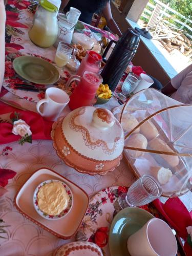 un tavolo con una torta e altro cibo sopra di Pousada Recanto Alegre a Campestre