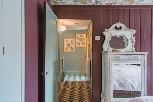 a hallway with a mirror and a bed in a room at Noggin in Deal