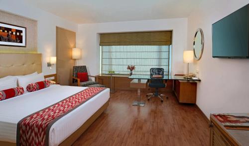 a hotel room with a bed and a desk at Radisson Mumbai Goregaon in Mumbai