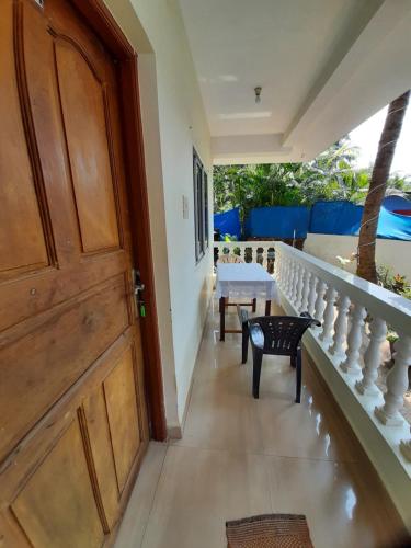 a hallway with a wooden door and stairs with a table at Santana Guest House in Agonda