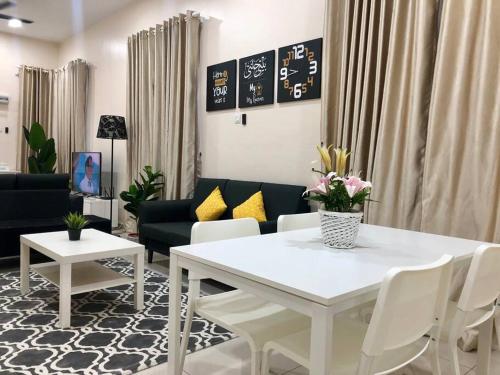 a living room with a white table and chairs at RumahKu Homestay, Taman Jasin Perdana in Jasin