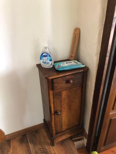 a small wooden cabinet with a bowl and a bottle on it at T3 LUC-LA-PRIMAUBE chez Monique 2 nuits minimum in Luc