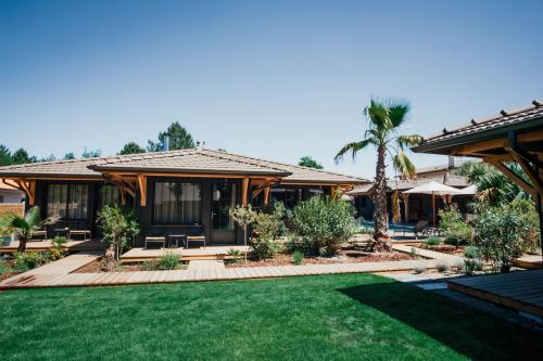 a house with a lawn in front of it at VillaCanau in Lacanau