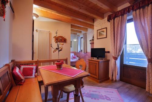 a living room with a table and a television at Park Hotel Leonardo in Moena