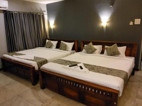 2 camas en una habitación de hotel con faldas en Le Grace Annasalai en Chennai