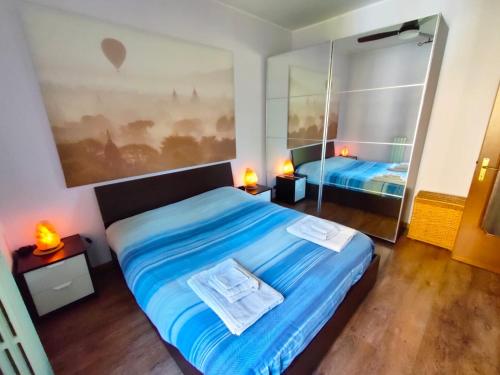 - une chambre dotée d'un lit avec des draps bleus et un miroir dans l'établissement Appartamento Il Girasole, à Casatenovo
