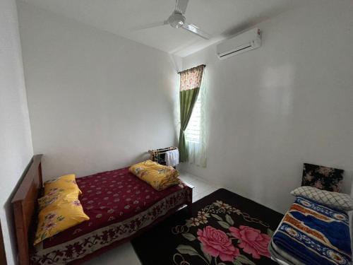 um pequeno quarto com uma cama e uma janela em Family Holiday Home With Wifi & Netflix em Sungai Petani