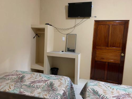 een slaapkamer met een bed en een tv aan de muur bij Casa de los abuelos in Salina Cruz