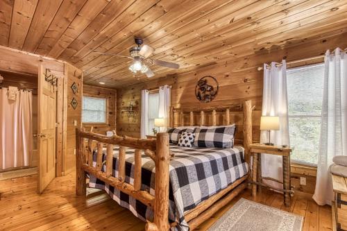een slaapkamer in een blokhut met een bed en een plafondventilator bij Dog Friendly, Quiet Chalet, Hot Tub, Fireplace in Sevierville