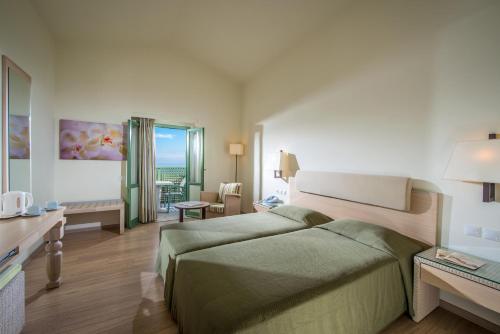 a hotel room with a bed and a living room at Silva Beach Hotel in Hersonissos