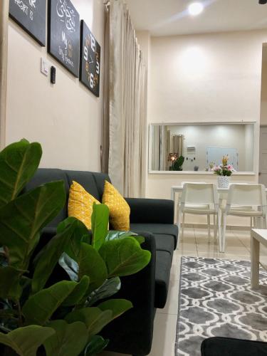 a living room with a black couch and yellow pillows at RumahKu Homestay, Taman Jasin Perdana in Jasin