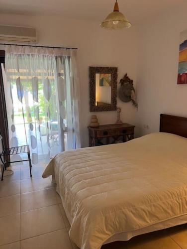 a bedroom with a bed and a window and a table at Villa Maria-Stunning Villa in Porto Hydra in Thermisía
