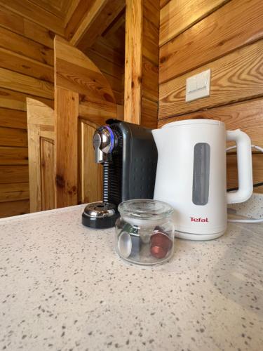 a coffee maker and a cup on a counter at أكواخ غيم ومطر in Al Hada