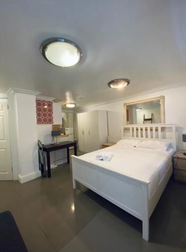 1 dormitorio con cama blanca y espejo en Lower ground Bell street, en Londres