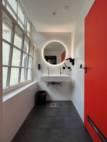 a bathroom with a sink and a mirror at Heart of Amsterdam Hostel in Amsterdam