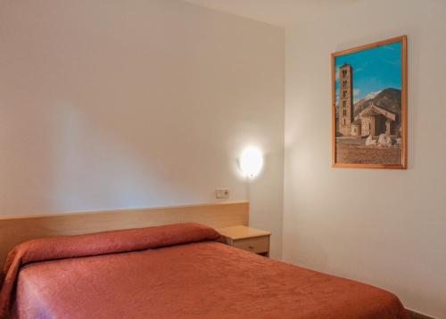 a bedroom with a bed and a painting on the wall at Hotel Saloria in Alins