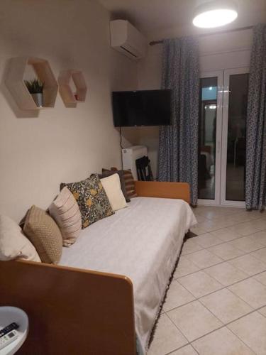 a bedroom with a bed and a flat screen tv at Ρετρό Κλινάρι in Xanthi