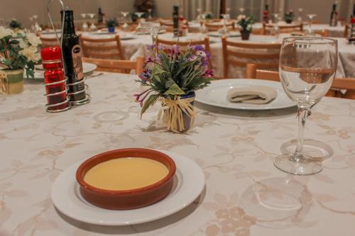 a table with two plates and a glass of wine at Hotel Saloria in Alins