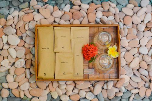 un tavolo con libri e un vaso di fiori con rocce di The MG Villa & SPA a Nusa Penida