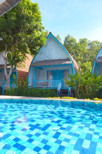 a blue house with a swimming pool in front of it at The MG Villa & SPA in Nusa Penida