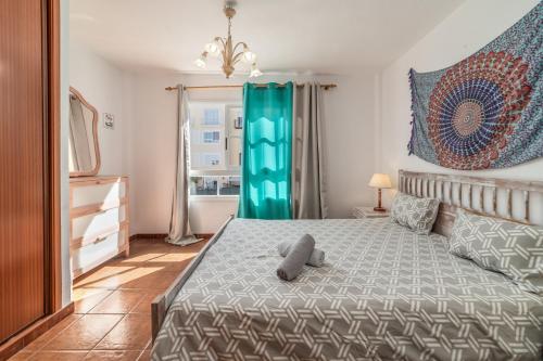 a bedroom with a bed with a teddy bear on it at Callao Salvaje, apartamento a 200 mts de la Playa in Alcalá