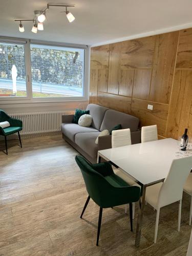 a living room with a couch and a table and chairs at Casa Lorica Marilleva 1400 in Marilleva