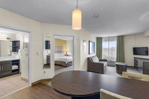 a living room with a table and a bedroom at Candlewood Suites Erie by IHG in Erie