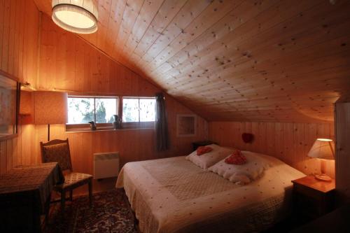 a bedroom with a bed in a wooden room at Heidi Chalet in Rossinière
