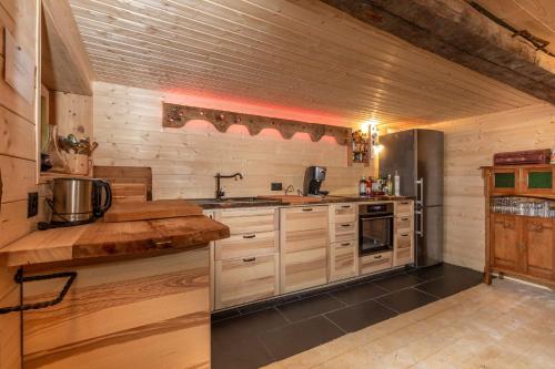 a kitchen with wooden cabinets and a counter top at Heidi Chalet in Rossinière