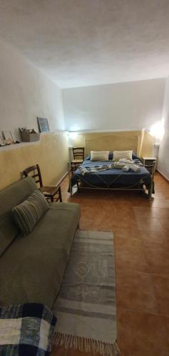 a living room with a bed and a couch at Casolare Al Porto in Tropea