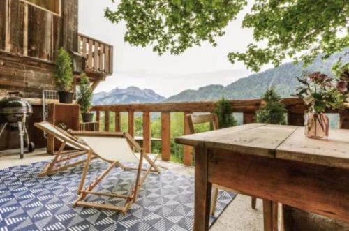 a patio with a table and chairs on a deck at Heidi Chalet in Rossinière