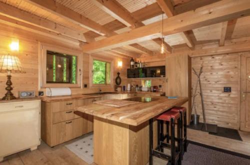 a large kitchen with wooden walls and a large island at Heidi Chalet in Rossinière