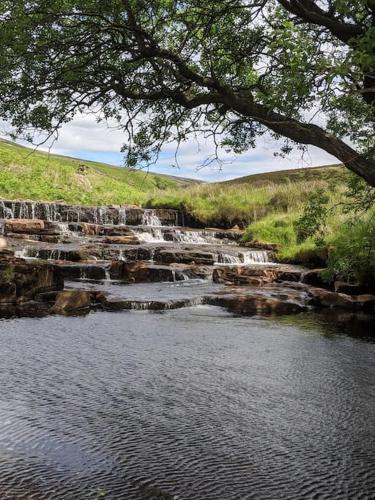 a group of waterfalls in the middle of a river at La'al Cabin, tiny home, unique space Eden Valley Cumbria in Brampton