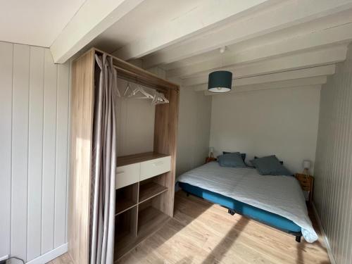 ein kleines Schlafzimmer mit einem Bett und einem Schreibtisch in der Unterkunft La ptite maison de Royan pour 4 personnes avec jardin in Royan