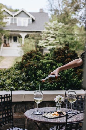 a woman pouring wine into two wine glasses on a table at Princess Anne Boutique Hotel in Asheville