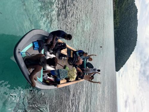 a group of people on a speed boat in the water at Warahnus dive homestay in Kri