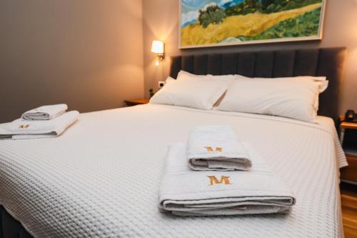a bed with towels sitting on top of it at Vila Mariss in Korçë