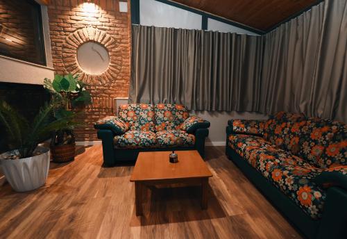 a living room with two couches and a coffee table at Vila Mariss in Korçë