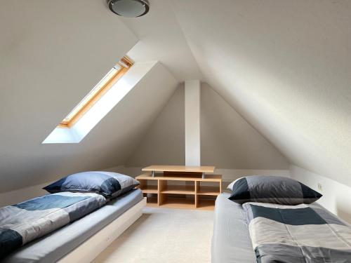 a attic bedroom with two beds and a skylight at Apartment an der Altstadt in Hameln