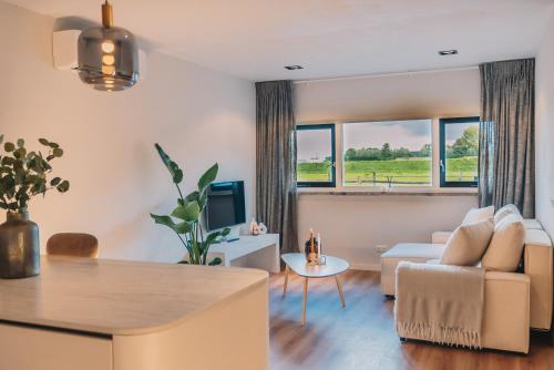 a living room with a couch and a table at Wellness Bed & Breakfast by Leef in Maasland