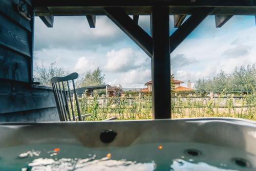 une baignoire assise devant une fenêtre dans l'établissement Wellness Bed & Breakfast by Leef, à Maasland