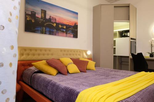 um quarto com uma cama com almofadas roxas e amarelas em LeNotti Verona em Verona