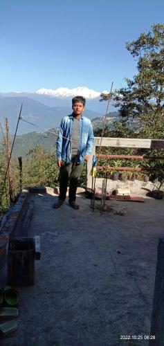 a man is standing on top of a mountain at Wonder Hill Parivaar homestay in Darjeeling