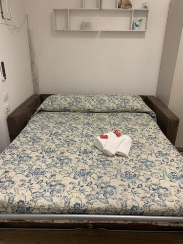- un lit avec deux chaussures blanches dans l'établissement La Finestra del Pescò, à Lerici