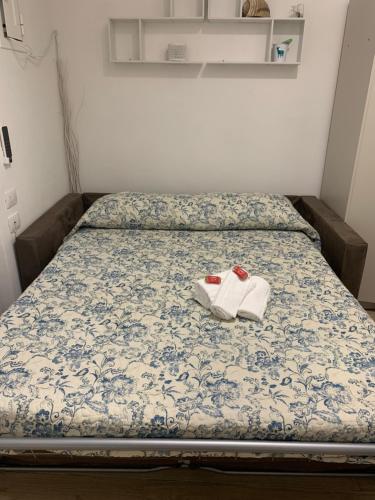 a bed with two white shoes sitting on it at La Finestra del Pescò in Lerici