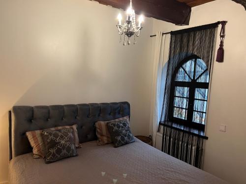 a bedroom with a bed and a chandelier at Tiltų 5 Apartment in Klaipėda
