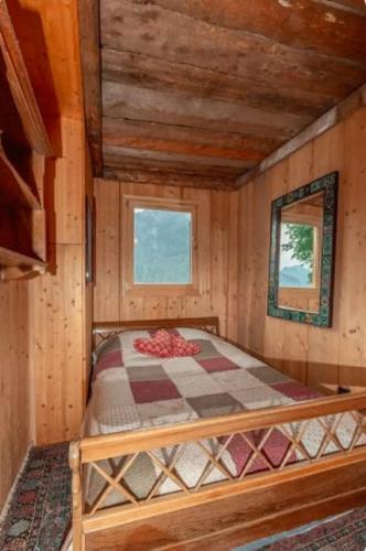 a bedroom with a bed in a wooden cabin at Heidi Chalet in Rossinière